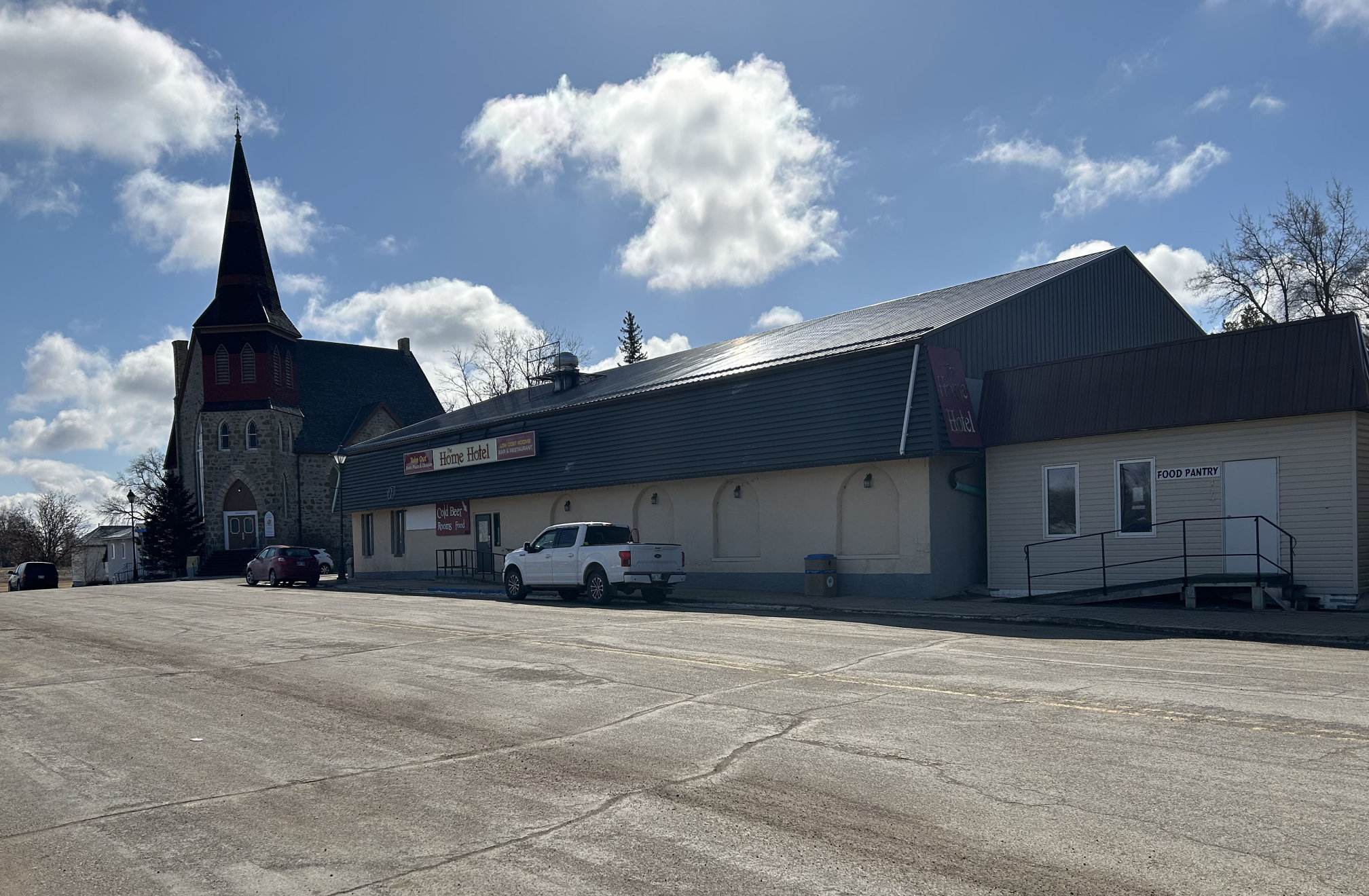 [2024 photo looking east at the Home Hotel (former Mansion House) with St Paul's United Church in the background]